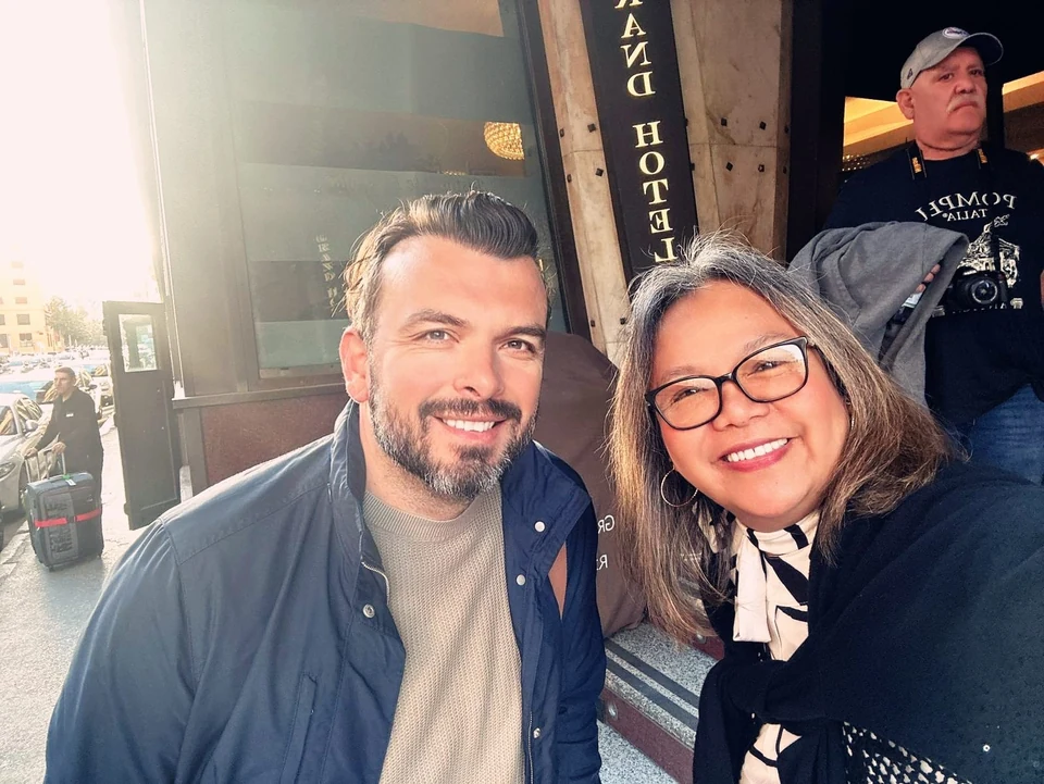 Sasha Rojnik smiling with a guest outside a hotel